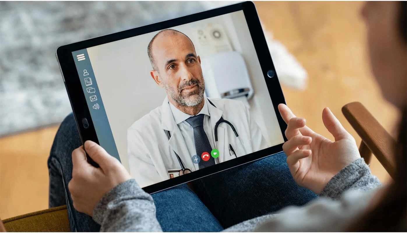 Image of a patient engaging in a virtual consultation with a healthcare professional via a tablet. Image of a patient engaging in a virtual consultation with a healthcare professional via a tablet.